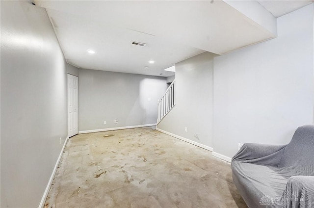 finished basement featuring visible vents, stairs, and baseboards