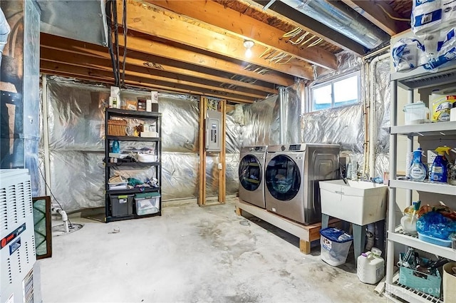 basement with washer and dryer, electric panel, and a sink