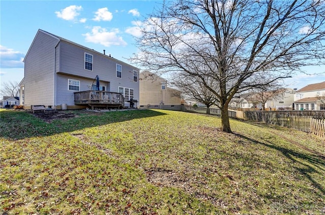 back of house with a yard, a fenced backyard, and a wooden deck