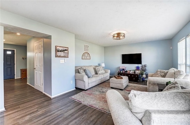 living room featuring baseboards and dark wood-style flooring