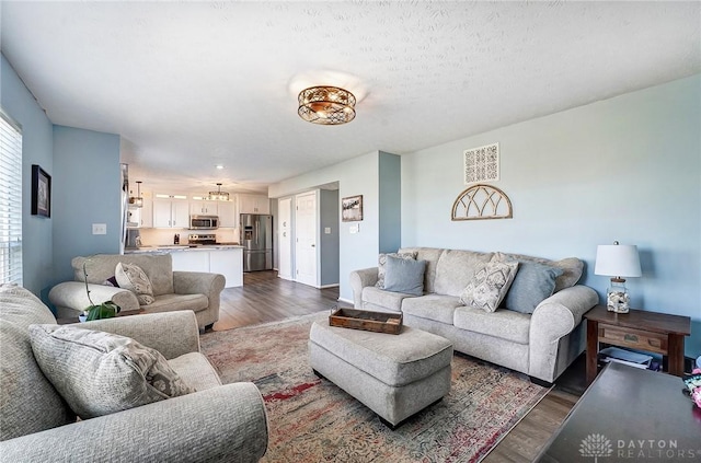 living area with a textured ceiling and dark wood finished floors