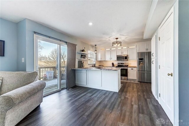 kitchen with dark wood-style floors, a peninsula, open shelves, appliances with stainless steel finishes, and open floor plan