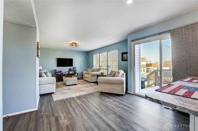 living area with baseboards and wood finished floors