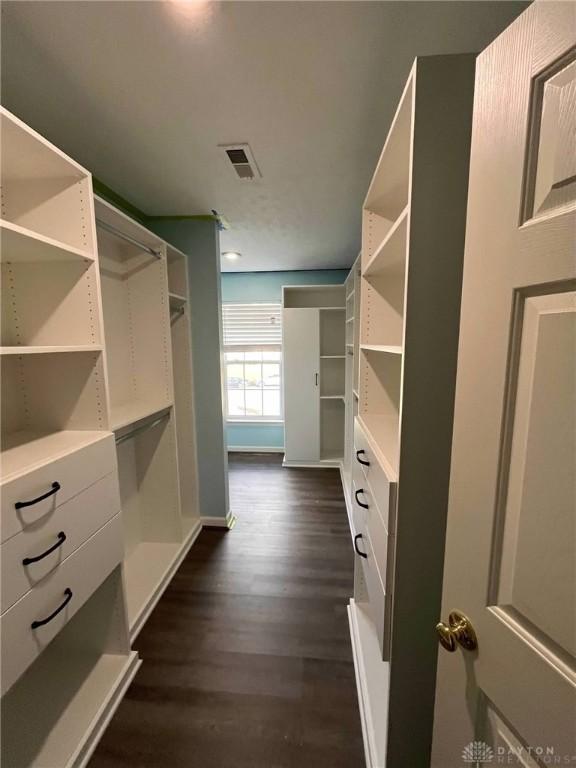 walk in closet with dark wood-style floors and visible vents