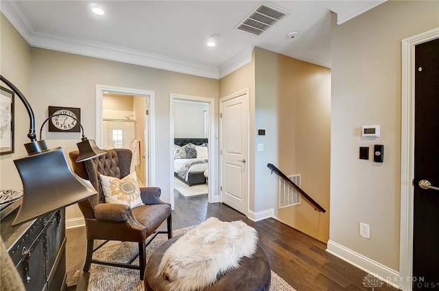 sitting room with visible vents, an upstairs landing, dark wood-style floors, and crown molding