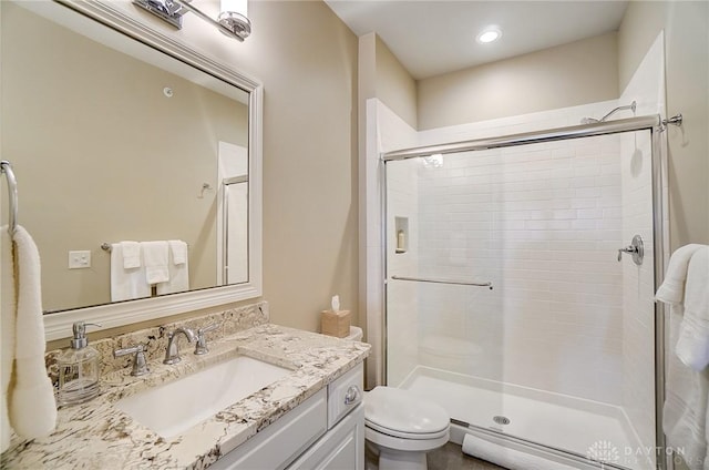 bathroom featuring recessed lighting, a stall shower, toilet, and vanity