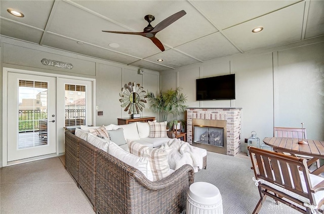 living room with a decorative wall, french doors, a fireplace, and a drop ceiling