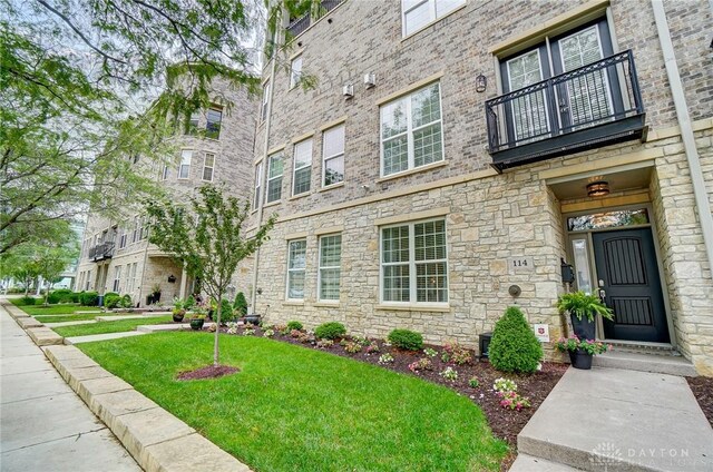 exterior space featuring a lawn and brick siding