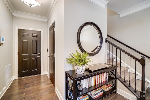 foyer featuring visible vents, baseboards, dark wood-style floors, and crown molding