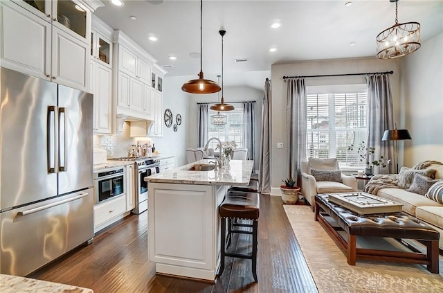 kitchen featuring a sink, stainless steel appliances, tasteful backsplash, and a healthy amount of sunlight