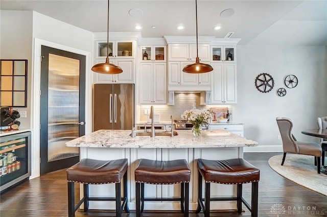 kitchen with decorative backsplash, a breakfast bar area, stainless steel appliances, and dark wood-style flooring