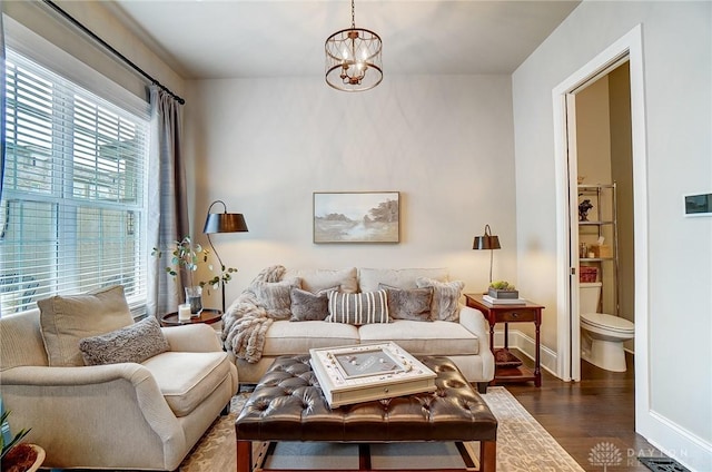 living room featuring visible vents, baseboards, a chandelier, and dark wood-style flooring