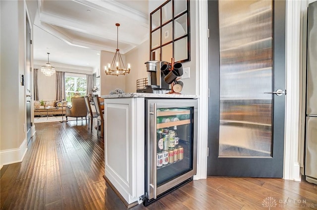 bar with wine cooler, pendant lighting, a dry bar, a notable chandelier, and dark wood-style flooring