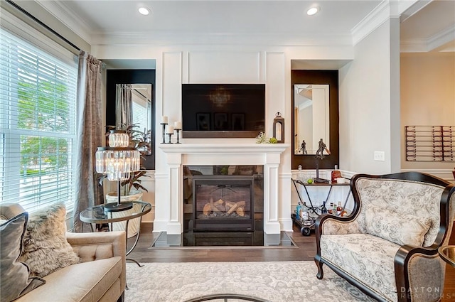 living room with a fireplace with flush hearth, wood finished floors, and ornamental molding