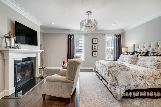 bedroom with a glass covered fireplace, baseboards, wood finished floors, and ornamental molding