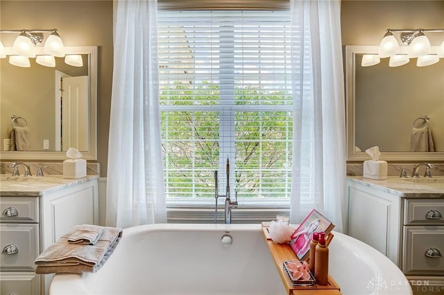 bathroom featuring a freestanding bath, a chandelier, and vanity