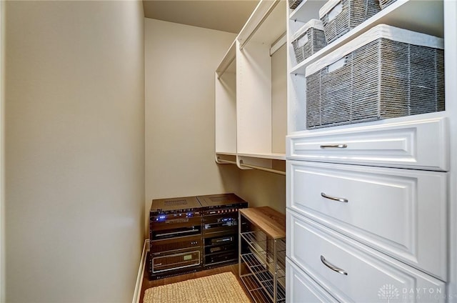 walk in closet featuring dark wood finished floors