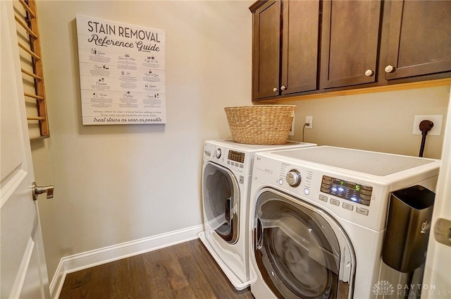 clothes washing area featuring baseboards, cabinet space, washing machine and dryer, and dark wood finished floors