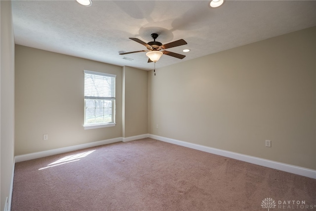 carpeted empty room featuring a ceiling fan, visible vents, baseboards, recessed lighting, and a textured ceiling