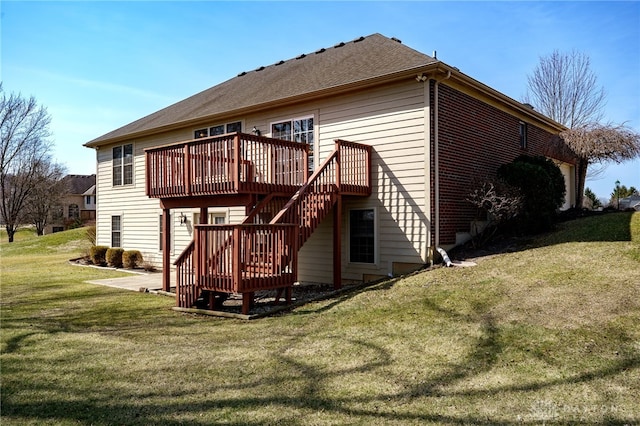 back of property with brick siding, a deck, stairs, and a yard