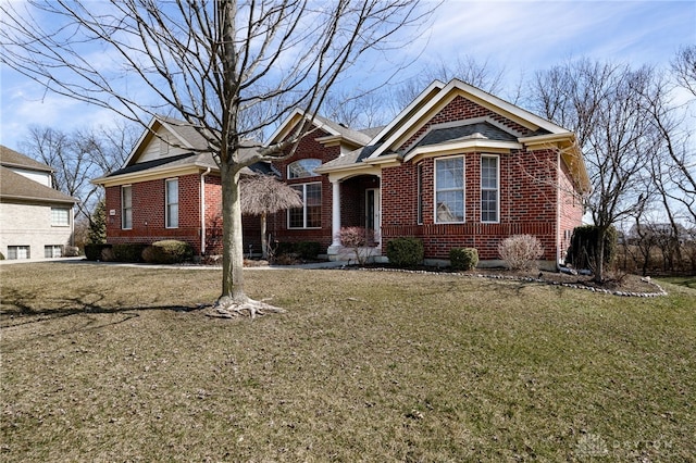 view of front facade featuring brick siding and a front yard