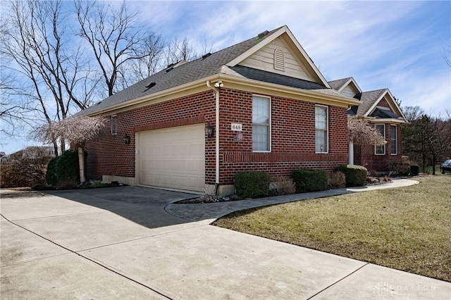 view of home's exterior with driveway, roof with shingles, an attached garage, a lawn, and brick siding