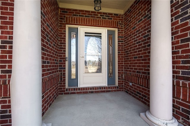 property entrance with a porch and brick siding