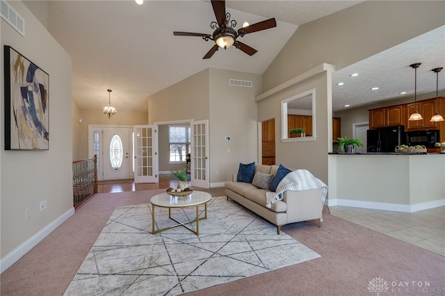 living area with light carpet, visible vents, and high vaulted ceiling