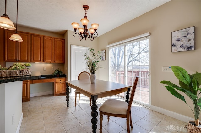 dining area with light tile patterned floors, baseboards, built in study area, a textured ceiling, and a notable chandelier