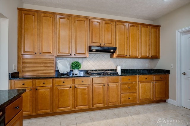 kitchen with under cabinet range hood and brown cabinets