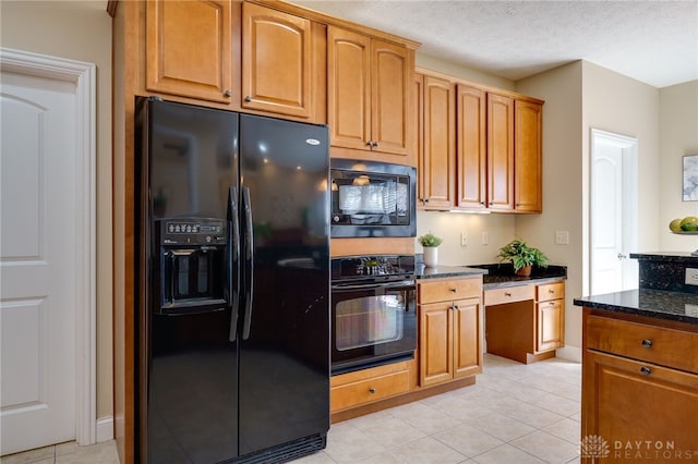 kitchen with black appliances, light tile patterned floors, dark stone countertops, brown cabinetry, and a textured ceiling