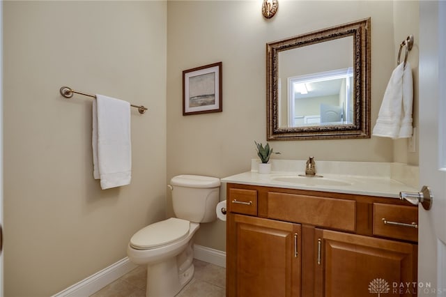 half bath with tile patterned flooring, toilet, vanity, and baseboards