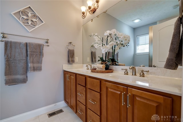 bathroom with double vanity, visible vents, tile patterned flooring, and a sink