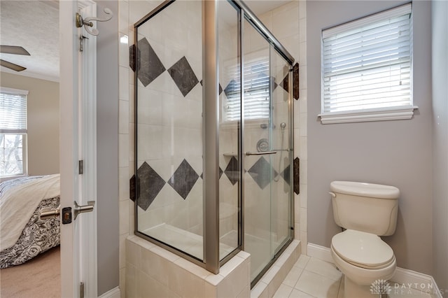 ensuite bathroom featuring plenty of natural light, toilet, ceiling fan, and a shower stall