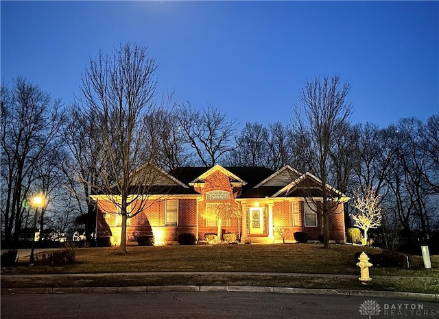 view of front facade with a front lawn and brick siding