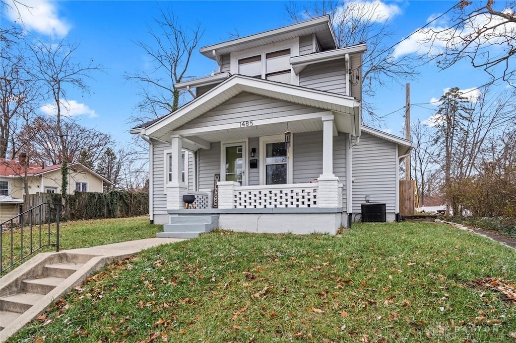 view of front of home featuring covered porch, a front lawn, central AC, and fence