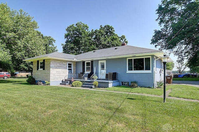 view of front facade with a front yard, stone siding, and a chimney