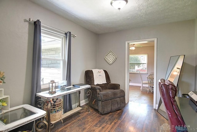 sitting room featuring baseboards, dark wood-type flooring, and a textured ceiling