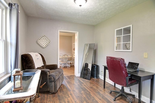 office space featuring a wealth of natural light, baseboards, a textured ceiling, and dark wood-style floors