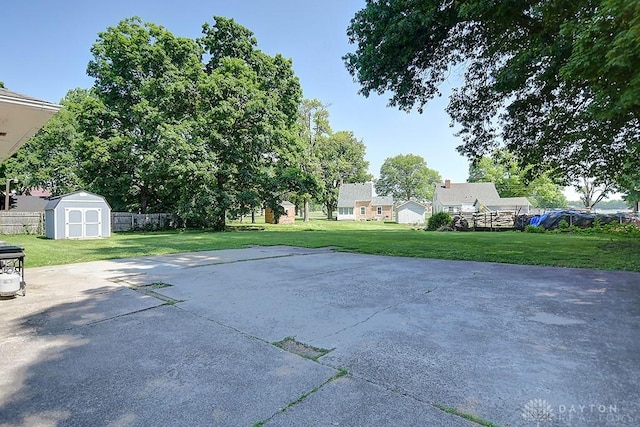 view of patio / terrace with fence, an outdoor structure, and a shed