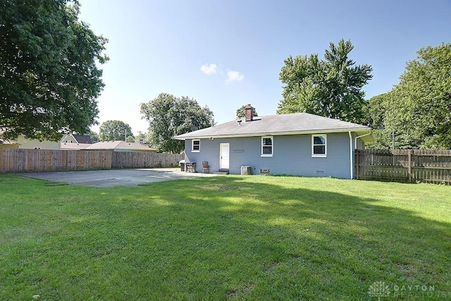 rear view of house featuring a patio, a yard, a fenced backyard, central AC, and crawl space