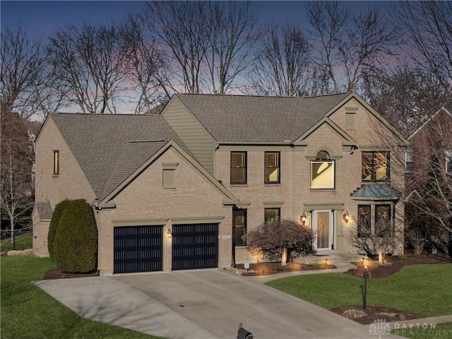 view of front of property with a yard, brick siding, driveway, and roof with shingles