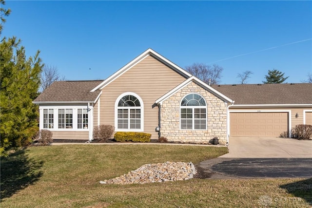 view of front of property with stone siding, a shingled roof, concrete driveway, an attached garage, and a front yard