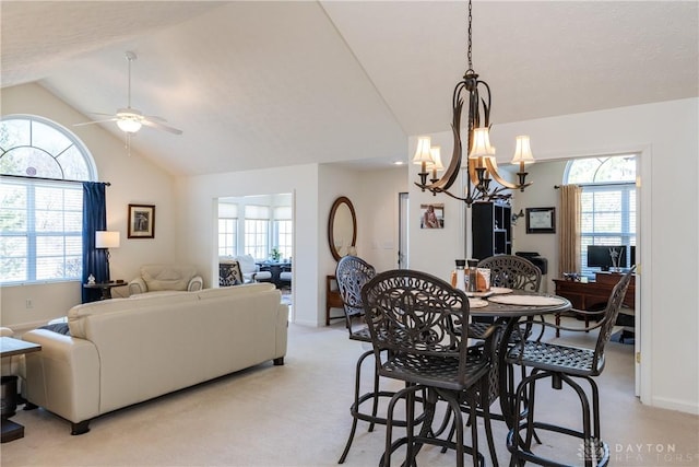 dining area with a ceiling fan, vaulted ceiling, a healthy amount of sunlight, and light colored carpet