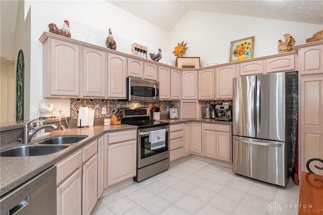 kitchen with light brown cabinetry, appliances with stainless steel finishes, and a sink