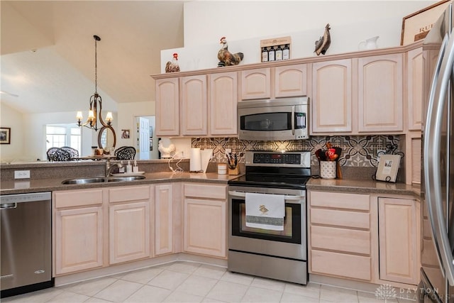 kitchen with light brown cabinetry, appliances with stainless steel finishes, lofted ceiling, and a sink