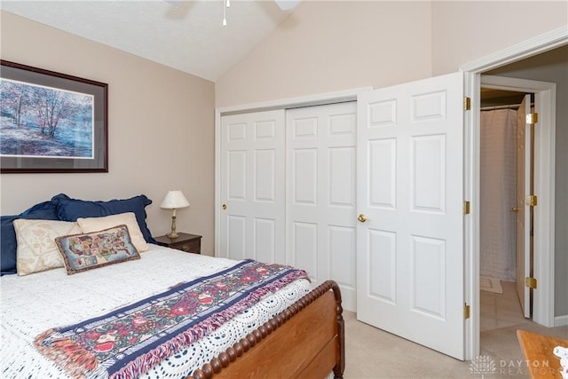 bedroom featuring a closet, light carpet, ceiling fan, and vaulted ceiling