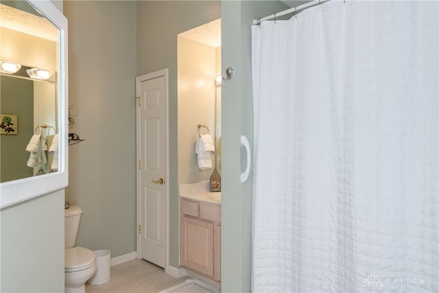 bathroom with tile patterned floors, toilet, curtained shower, baseboards, and vanity