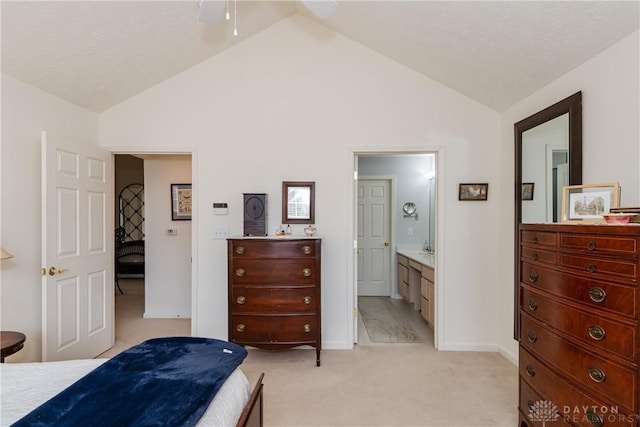 bedroom featuring light carpet, ensuite bathroom, and vaulted ceiling