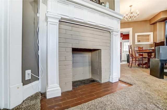 interior details with an inviting chandelier, carpet flooring, and decorative columns